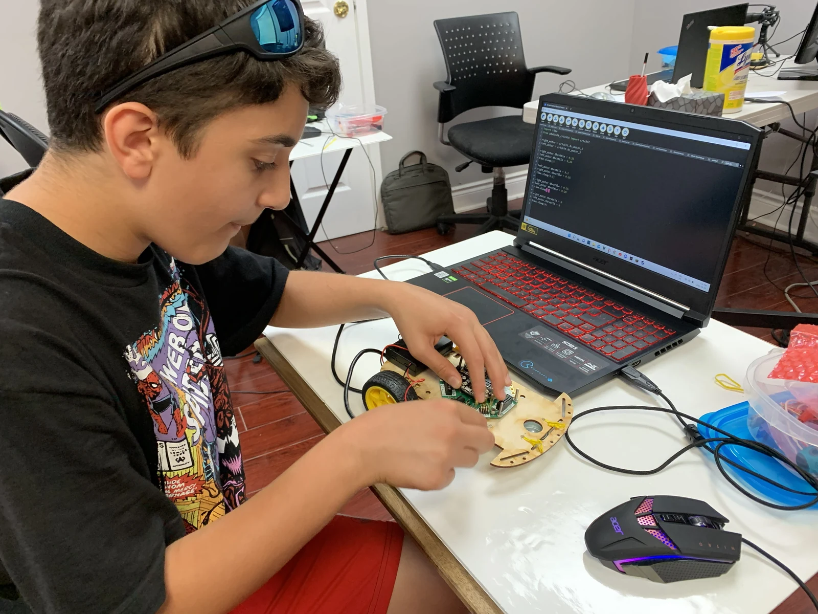 Student programming a robot with a laptop at My Code Club